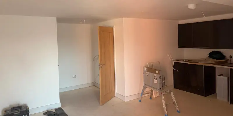 Fire door repair work in progress with tools and stepladder in a flat